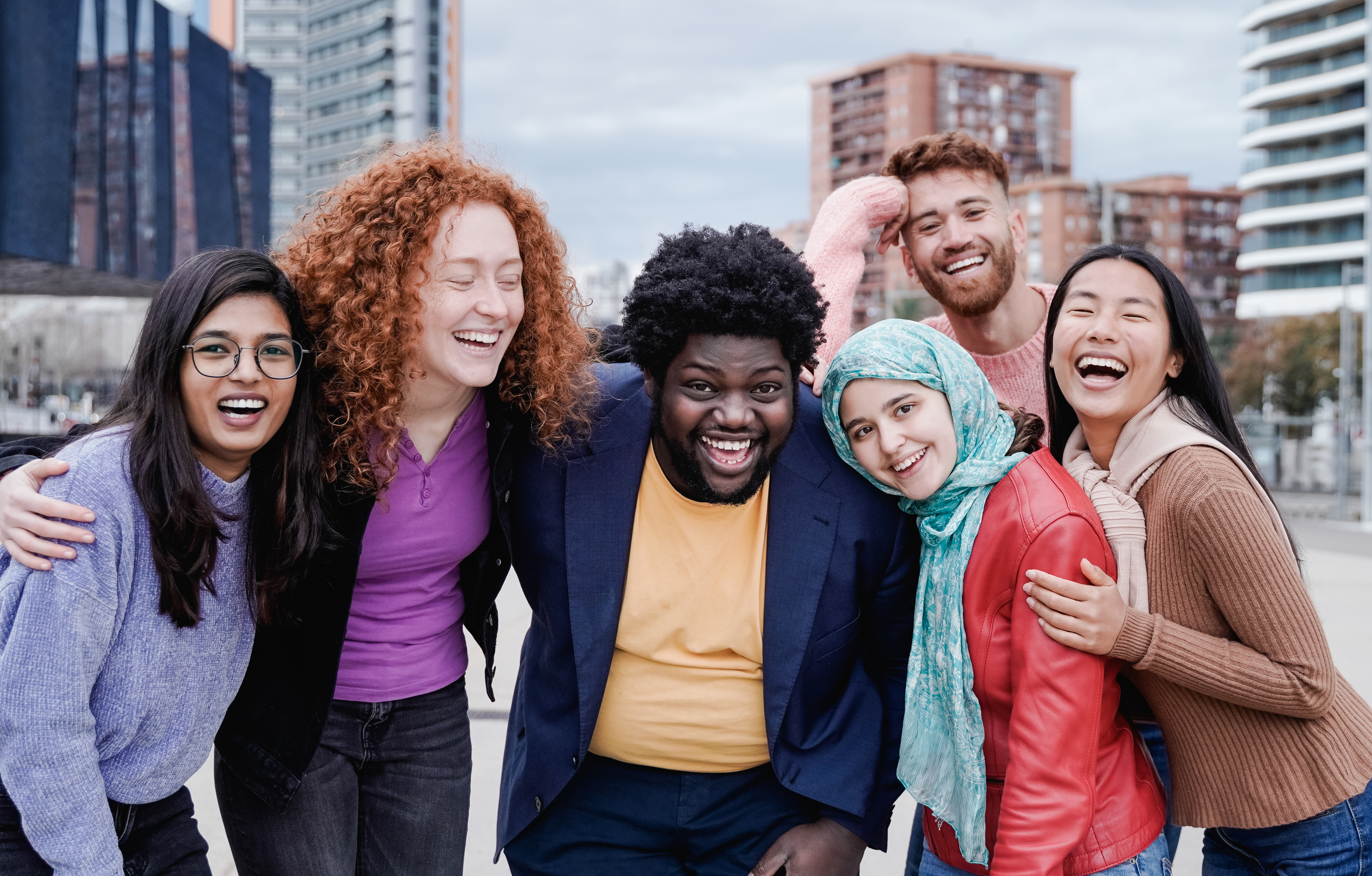 Multiracial happy friends having fun outdoor in the city - Main focus on african curvy man